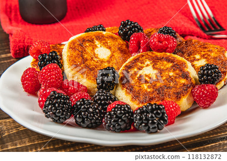 Fresh cottage cheese pancakes with raspberry blackberry on a white plate Fresh cottage cheese pancakes with raspberry blackberry on a white plate 118132872
