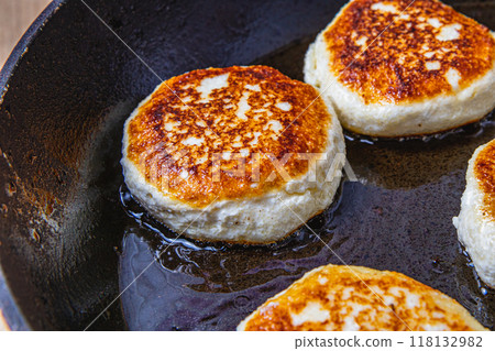 Cottage cheese pancakes are fried in a pan before being pulled out 118132982