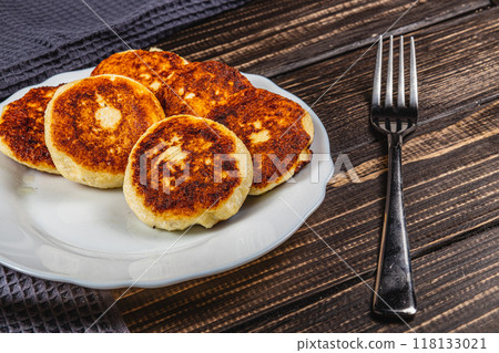 Fresh fried cottage cheese pancakes on a white plate 118133021