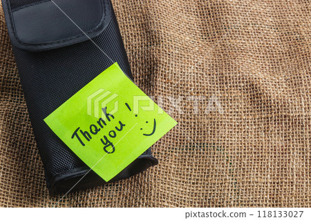 Black box on knitted background with green thank you label Black box on knitted background with green thank you label 118133027