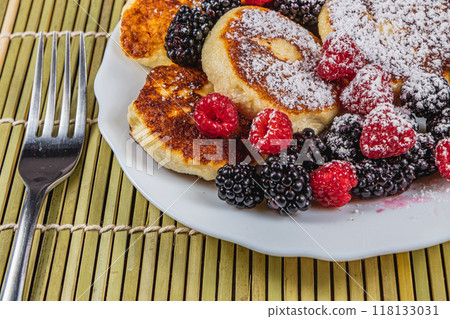 Cottage cheese pancakes with fresh raspberries, blackberries and powdered sugar 118133031
