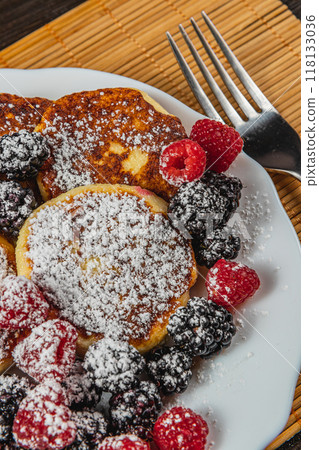 Cottage cheese pancakes with fresh raspberries, blackberries and powdered sugar 118133036