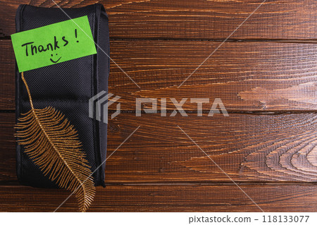 Black box on table with green thank you label and gold decorative leaf Black box on table with green thank you label and gold decorative leaf 118133077