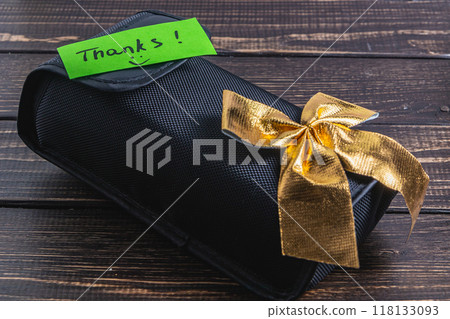 A black soft box with a green thank you label and a gold bow at the bottom A black soft box with a green thank you label and a gold bow at the bottom 118133093