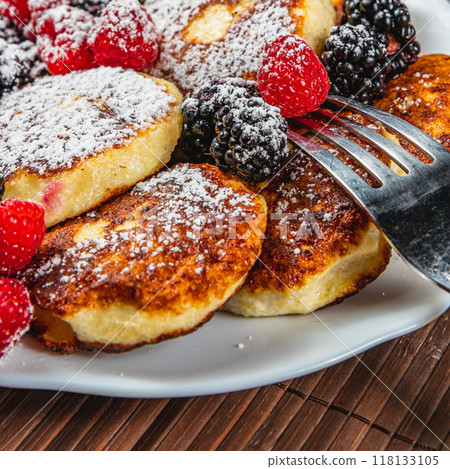 Cottage cheese pancakes with fresh raspberries, blackberries and powdered sugar 118133105