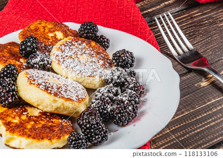 Cottage cheese pancakes with fresh blackberries on a white flat white plate 118133106
