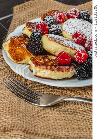 Cottage cheese pancakes with fresh raspberries, blackberries and powdered sugar 118133206