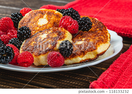 Fresh cottage cheese pancakes with raspberry blackberry on a white plate 118133232