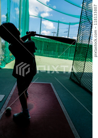 An elementary school student practices at a batting center, dreaming of becoming a baseball player in the future. An elementary school student practices at a batting center, dreaming of becoming a baseball player in the future. 118133807