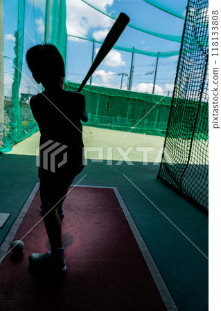 An elementary school student practices at a batting center, dreaming of becoming a baseball player in the future. 118133808