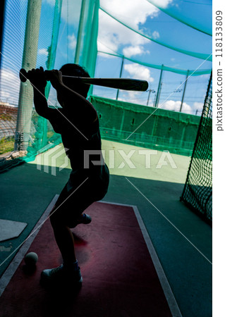 An elementary school student practices at a batting center, dreaming of becoming a baseball player in the future. An elementary school student practices at a batting center, dreaming of becoming a baseball player in the future. 118133809