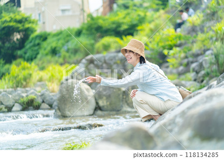 A woman playing by the river, a woman traveling, a woman enjoying her holiday 118134285