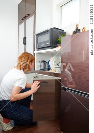 Woman opening cupboard, housewife, housework, cooking, cleaning up Woman opening cupboard, housewife, housework, cooking, cleaning up 118136531