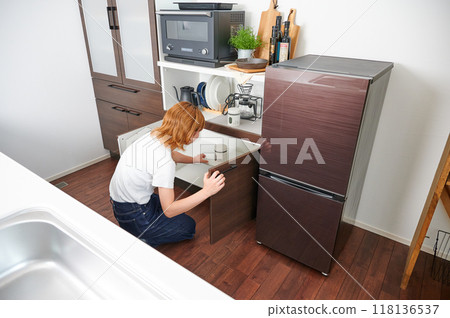 Woman opening cupboard, housewife, housework, cooking, cleaning up Woman opening cupboard, housewife, housework, cooking, cleaning up 118136537
