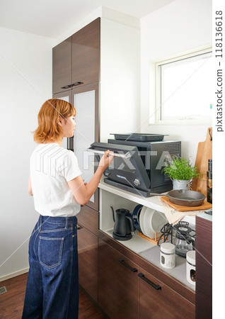 Woman operating a microwave cooking 118136618