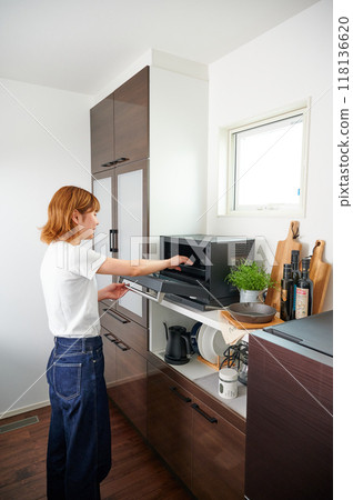 Woman operating a microwave cooking 118136620