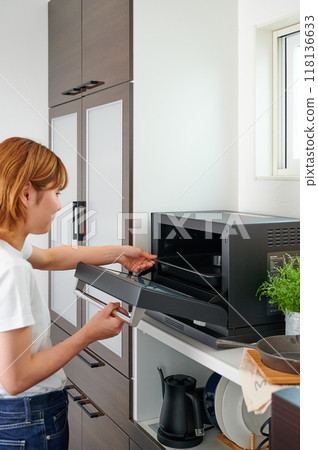 Woman operating a microwave cooking 118136633