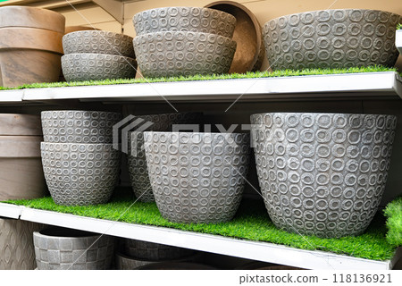 Textured stone planters displayed on shelves in a garden store. 118136921