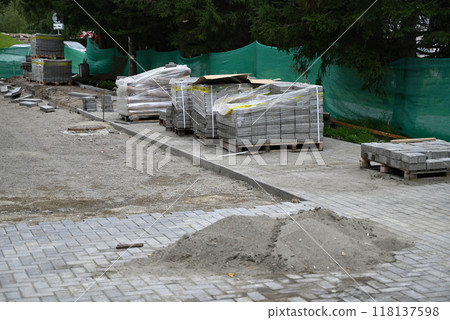 Low angle view of male hands measuring and leveling sand and cement tiles for precise pavement of the outside patio or sidewalk. Construction industry and renovation. Low angle view of male hands measuring and leveling sand and cement tiles for precise pavement of the outside patio or sidewalk. Construction industry and renovation. 118137598