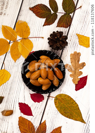 Autumn, fall leaves, hot steaming cup of coffee and a warm scarf on wooden table background. Seasonal, morning coffee, Sunday relaxing and still life concept. 118137606