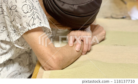 Elderly woman lying face down on a table_close-up from the side 118137710