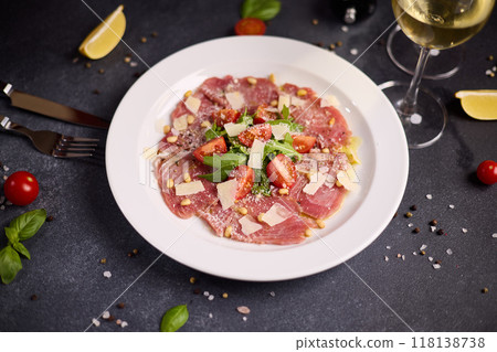 cooking tuna carpaccio - cherry tomato pieces on a plate with raw tuna fillet slices 118138738