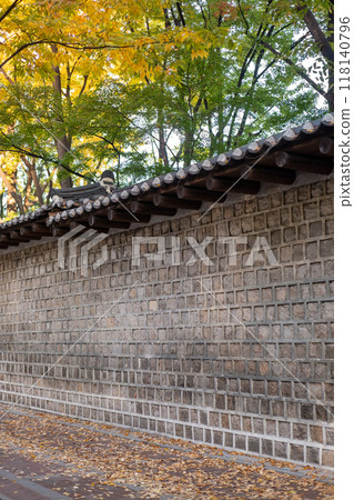 Deoksugung Stonewall Walkway with beautiful autumn foliage. It is the pedestrian footpath that runs next to Deoksugung Palace in Seoul, South Korea Deoksugung Stonewall Walkway with beautiful autumn foliage. It is the pedestrian footpath that runs next to Deoksugung Palace in Seoul, South Korea 118140796