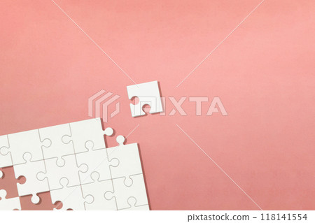 Pink background with a corner piece missing from a white puzzle Pink background with a corner piece missing from a white puzzle 118141554
