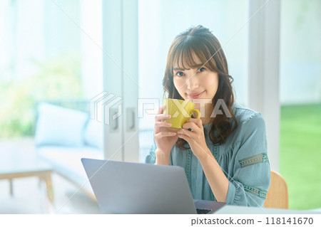 Young woman operating a personal computer at home Young woman operating a personal computer at home 118141670