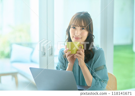 Young woman operating a personal computer at home Young woman operating a personal computer at home 118141671