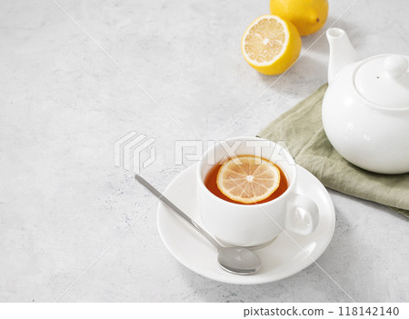 A cup of herbal tea with lemon and teapot on a light  background. Healthy and detox drink concept. 118142140