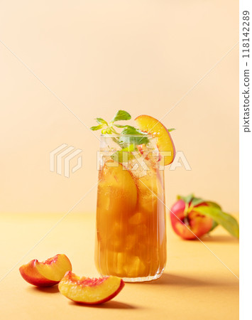 Refreshing peach ice and mint tea. Vegan homemade cold summer drink on tall glass Refreshing peach ice and mint tea. Vegan homemade cold summer drink on tall glass 118142289