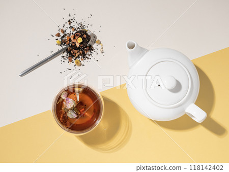 Creative flat lay of a glass cup of herbal tea with rose flowers on a yellow and white background Creative flat lay of a glass cup of herbal tea with rose flowers on a yellow and white background 118142402