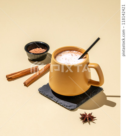 Yellow cup  with foamy drink coffee latte, hot chocolate or cocoa with cinnamon sticks 118142421
