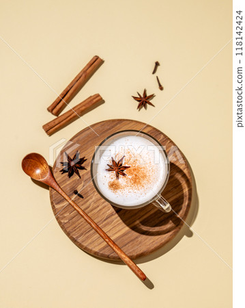 Traditional Indian masala chai latte in a glass cup. Hot drink with milk, spices and herbs  118142424