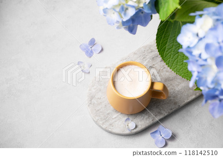 Spring bouquet with blue hydrangea flowers and a cup of cappuccino coffee in a yellow cup 118142510
