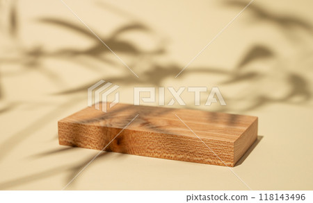 Empty wooden board with shadows and green leaves on a yellow background with shadow. 118143496