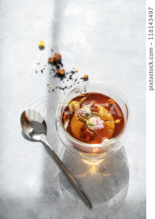 Cup of herbal tea on blue background with spoon and morning sunlight with shadow. Cup of herbal tea on blue background with spoon and morning sunlight with shadow. 118143497