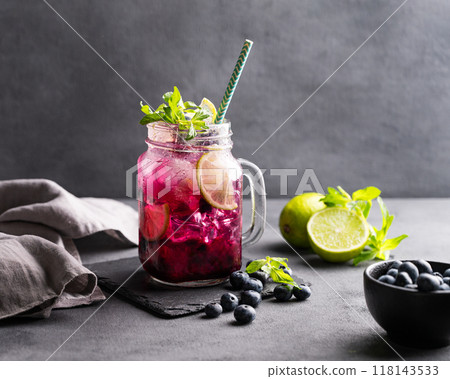 Refreshing blueberry mojito or lemonade with lime, mint and ice on a dark background.  118143533