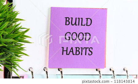 Business, psychological and build good habits concept. BUILD GOOD HABITS on a purple sticker on the background of a white leaf and a green plant in the foreground Business, psychological and build good habits concept. BUILD GOOD HABITS on a purple sticker on the background of a white leaf and a green plant in the foreground 118143814
