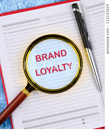 Conceptual brand loyalty symbol. Copy space. BRAND LOYALTY in an open notebook through a magnifying glass, top view Conceptual brand loyalty symbol. Copy space. BRAND LOYALTY in an open notebook through a magnifying glass, top view 118143829