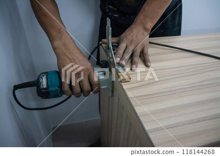worker using a gouge on an old wooden cabinet worker using a gouge on an old wooden cabinet 118144268