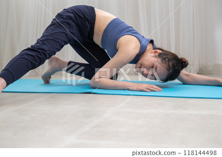 Woman in sportswear doing yoga poses online 118144498