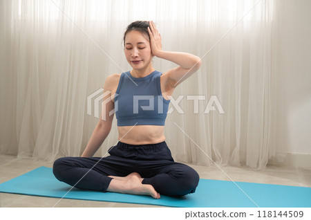 Woman in sportswear doing yoga poses online 118144509