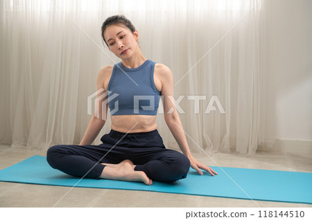 Woman in sportswear doing yoga poses online 118144510