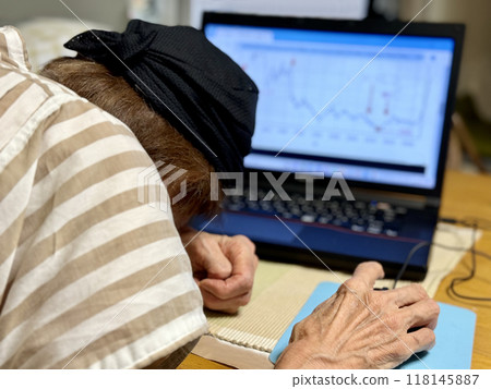 Elderly woman burying her face in front of a laptop screen 118145887