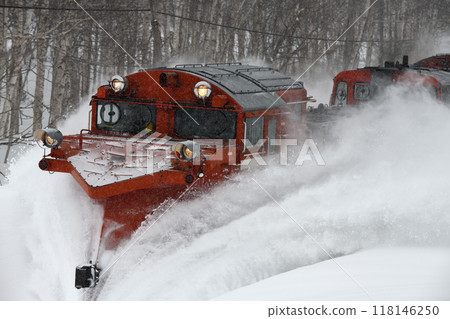 A snow-clearing train running through the snow 118146250
