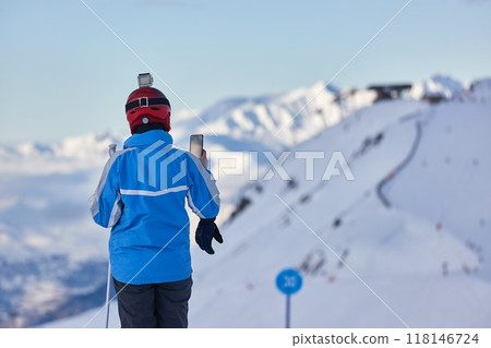 Skiing in the winter snowy slopes, woman on top taking photo 118146724