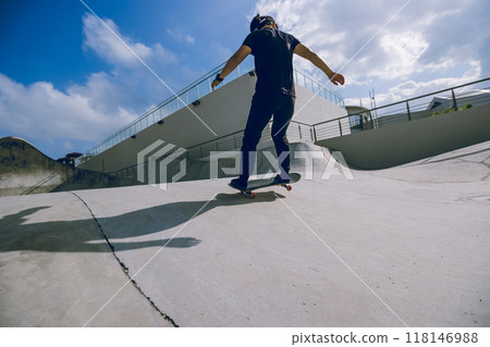 Skateboarder skateboarding at skatepark in city Skateboarder skateboarding at skatepark in city 118146988