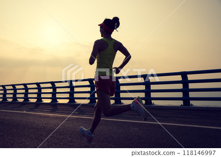 Fitness woman runner running on seaside bridge Fitness woman runner running on seaside bridge 118146997